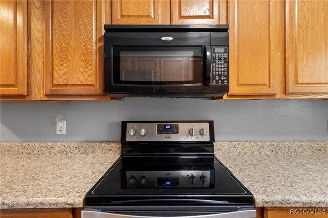 kitchen with stainless steel range with electric stovetop and black microwave