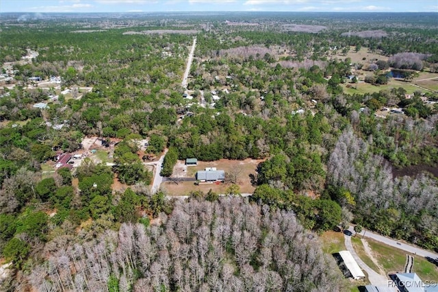 birds eye view of property featuring a forest view