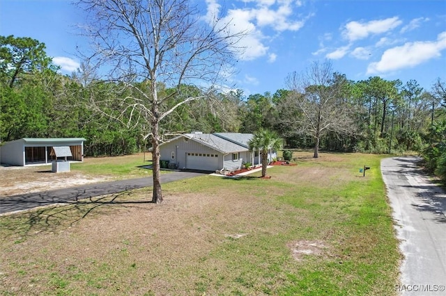 view of front of home with aphalt driveway, a garage, and a front yard