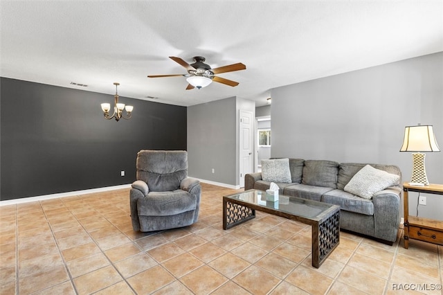 living area featuring light tile patterned floors, ceiling fan with notable chandelier, visible vents, and baseboards