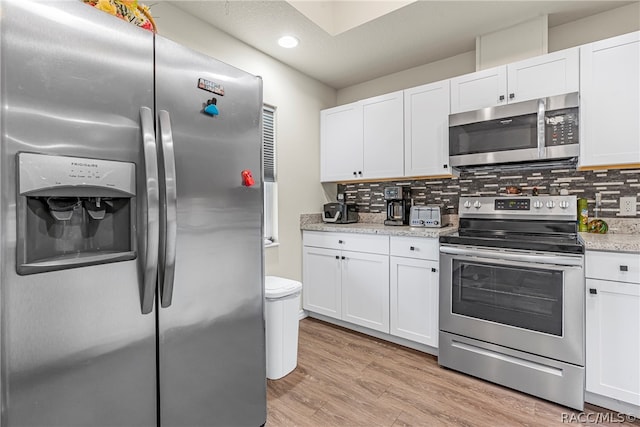 kitchen with white cabinets, backsplash, and stainless steel appliances