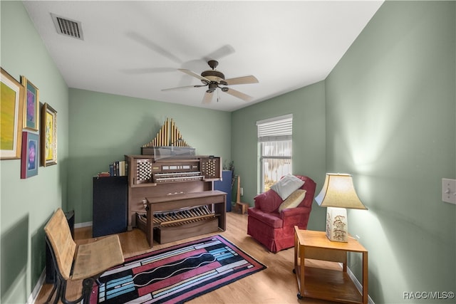 living area featuring ceiling fan and light hardwood / wood-style floors