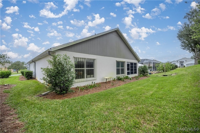 view of home's exterior featuring a lawn and a lanai