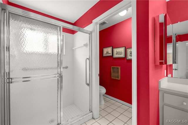 bathroom with tile patterned flooring, vanity, toilet, and walk in shower