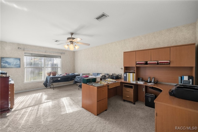 carpeted home office featuring ceiling fan