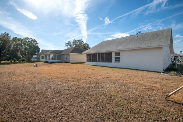 rear view of house featuring a lawn