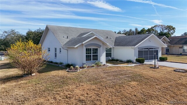 single story home featuring a garage and a front lawn