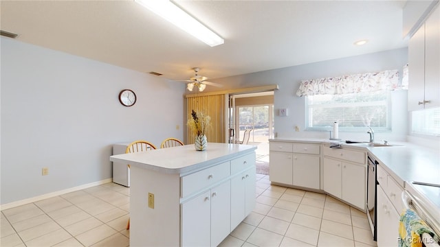 kitchen with a center island, white stove, white cabinets, ceiling fan, and light tile patterned floors