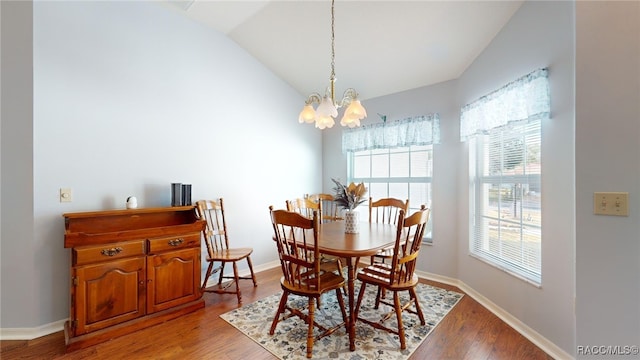 dining area with light hardwood / wood-style floors, vaulted ceiling, and an inviting chandelier