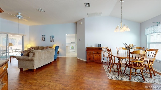 dining area with dark hardwood / wood-style floors, lofted ceiling, and ceiling fan with notable chandelier