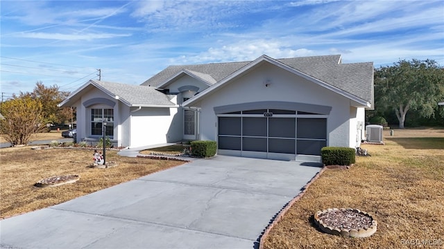 view of front facade with cooling unit, a front yard, and a garage