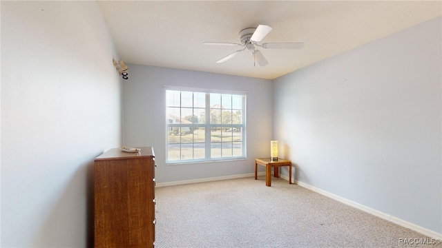 carpeted spare room featuring ceiling fan