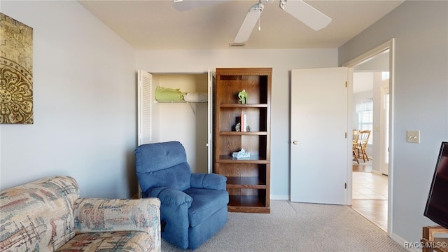 living area featuring ceiling fan and light colored carpet