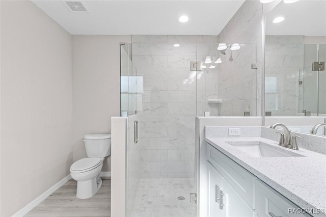 bathroom featuring walk in shower, hardwood / wood-style flooring, vanity, and toilet