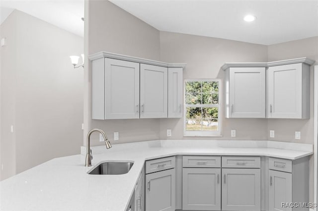 kitchen featuring sink, gray cabinetry, and light stone counters