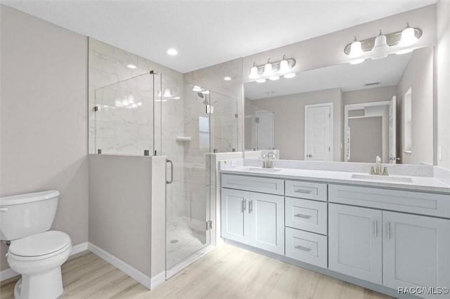 bathroom featuring toilet, an enclosed shower, vanity, and wood-type flooring