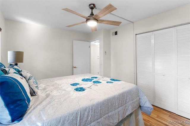 bedroom with ceiling fan, a closet, and hardwood / wood-style flooring