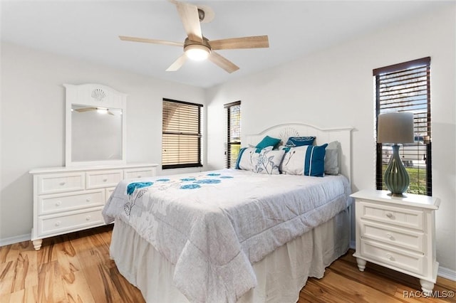 bedroom with multiple windows, light hardwood / wood-style flooring, and ceiling fan