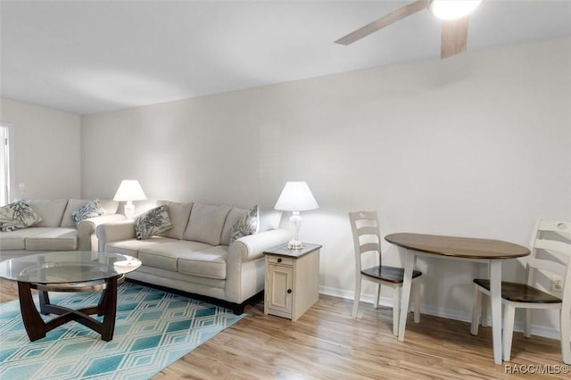 living room featuring ceiling fan and light hardwood / wood-style floors