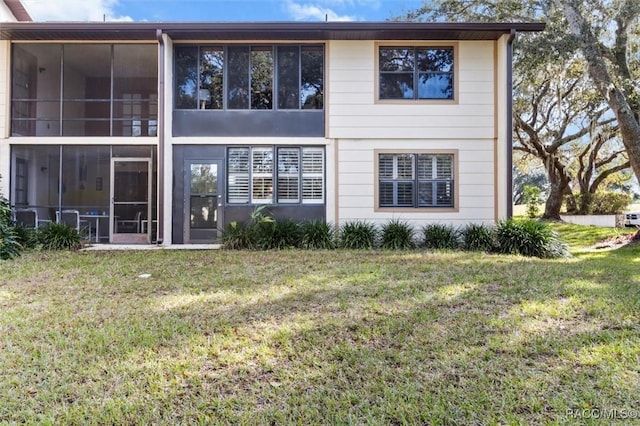 back of house with a lawn and a sunroom