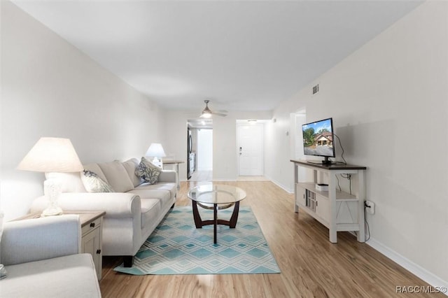 living room with ceiling fan and light hardwood / wood-style floors