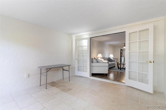 interior space with ceiling fan and french doors