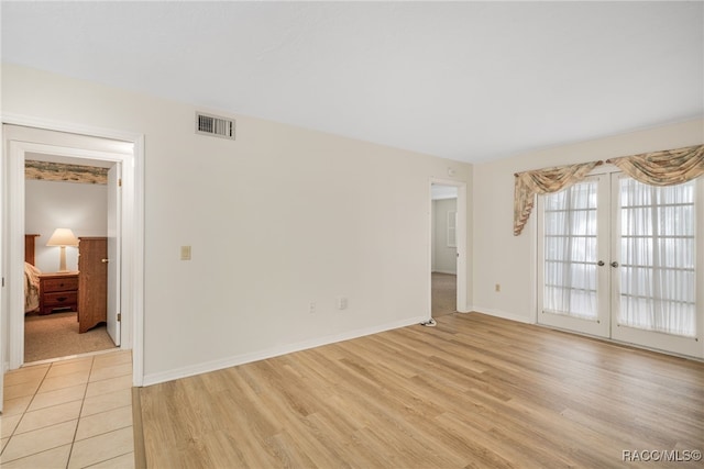 unfurnished room featuring light wood-type flooring and french doors