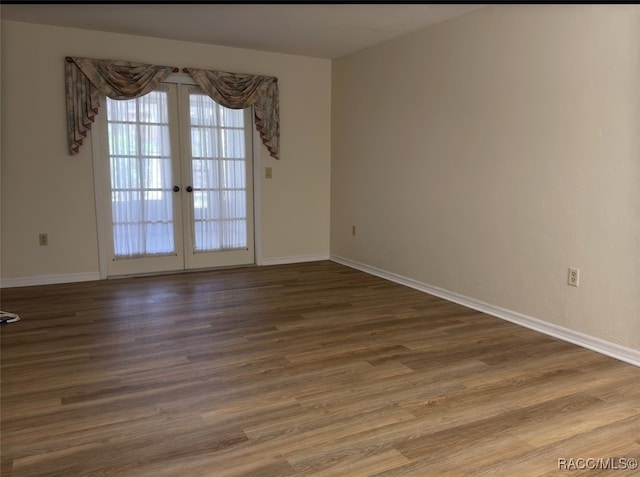 empty room with hardwood / wood-style flooring and french doors