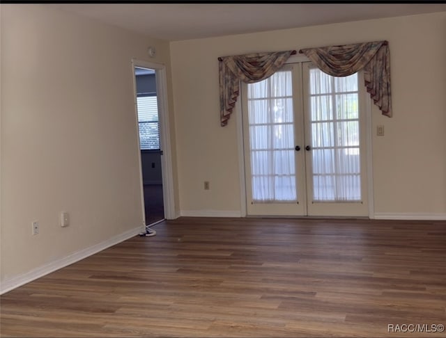 empty room with french doors and hardwood / wood-style floors