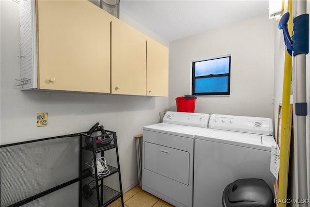 washroom with cabinets, light tile patterned floors, and washing machine and dryer