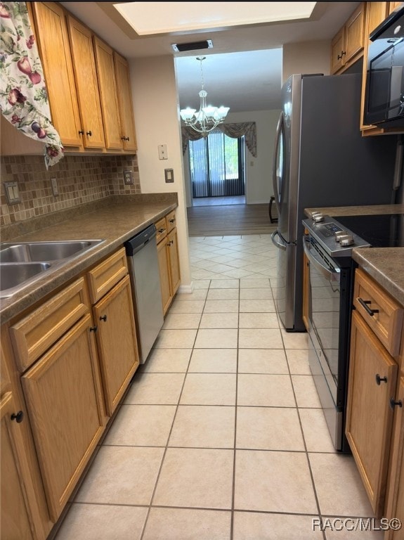 kitchen with pendant lighting, tasteful backsplash, a chandelier, light tile patterned floors, and black appliances