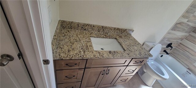 bathroom featuring toilet and vanity