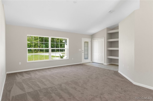 unfurnished living room featuring carpet flooring, built in features, and vaulted ceiling