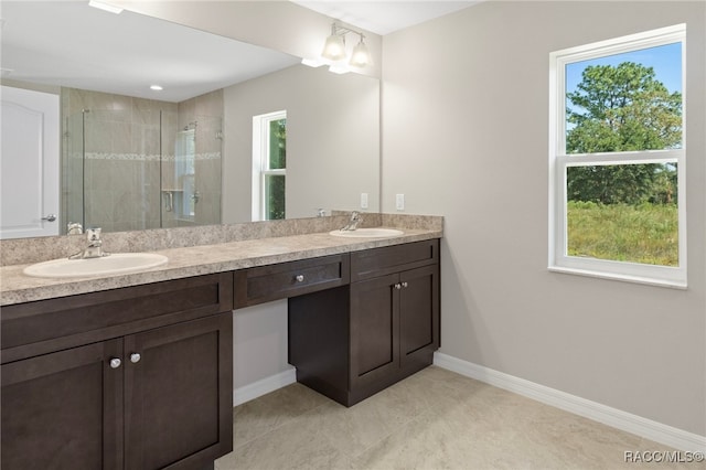 bathroom with tile patterned floors, a shower with door, vanity, and a healthy amount of sunlight