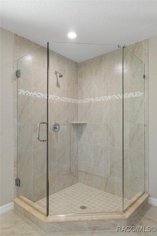 bathroom featuring tile patterned floors and an enclosed shower