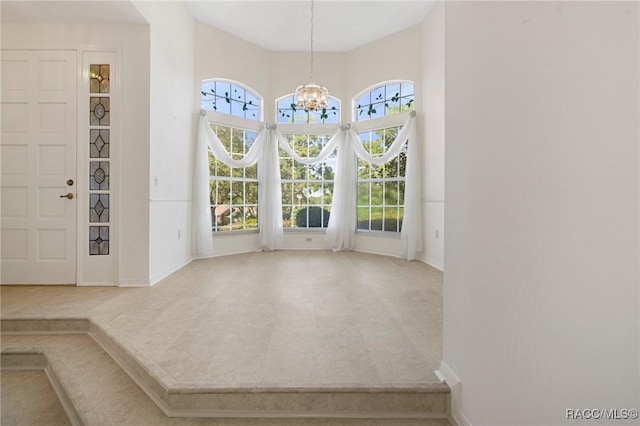 unfurnished dining area featuring carpet floors and a notable chandelier