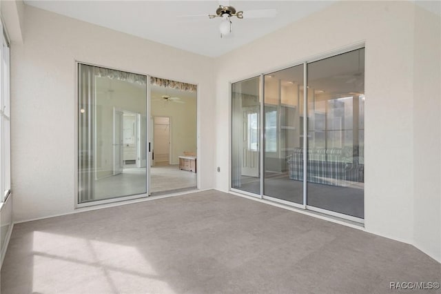 carpeted spare room with ceiling fan