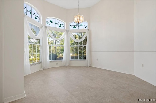 unfurnished dining area with a chandelier and light colored carpet