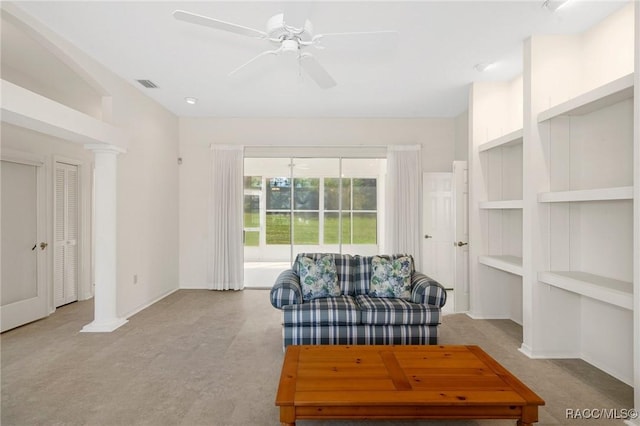 sitting room with ceiling fan, built in features, light carpet, and ornate columns