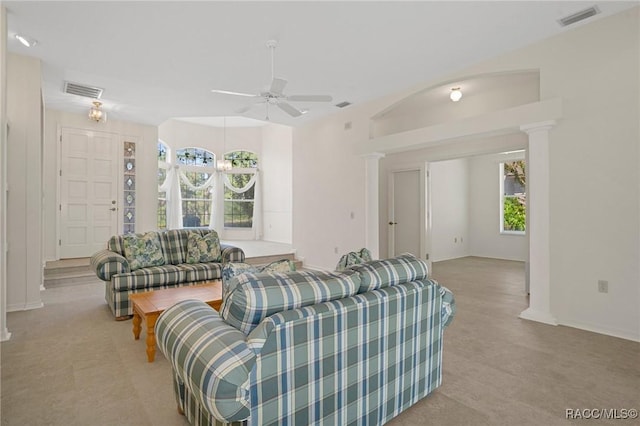 carpeted living room with ornate columns, a wealth of natural light, and ceiling fan