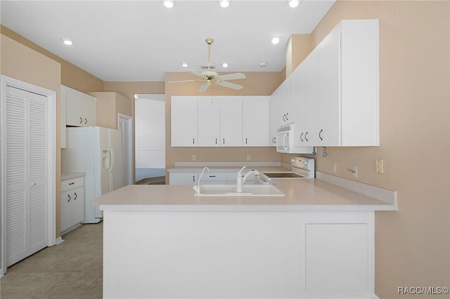 kitchen featuring kitchen peninsula, white cabinetry, sink, and white appliances