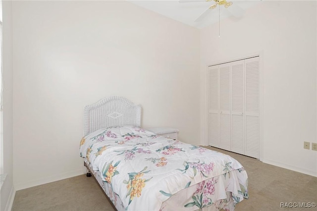 bedroom featuring ceiling fan, light colored carpet, and a closet