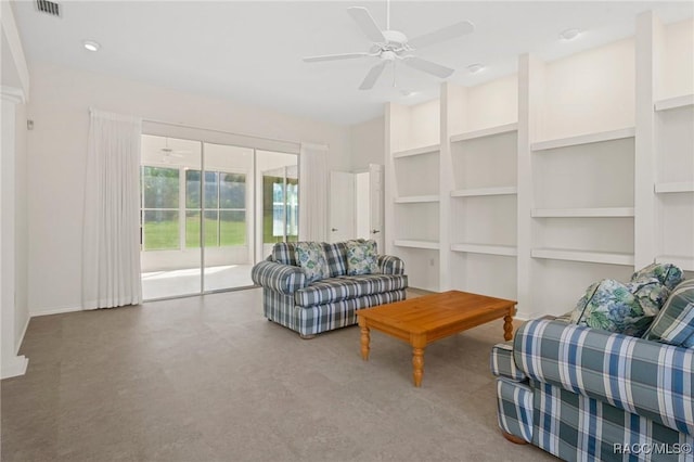 living room with built in shelves and ceiling fan