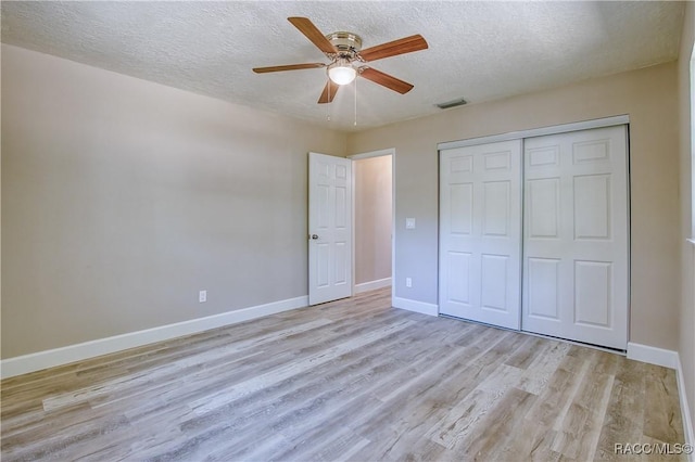 unfurnished bedroom featuring a textured ceiling, light wood-type flooring, visible vents, and baseboards