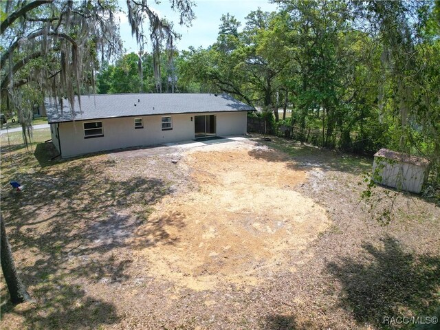 back of property with a storage shed, fence, and an outdoor structure