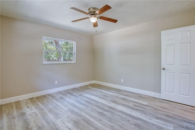 empty room featuring light wood-type flooring, baseboards, and ceiling fan