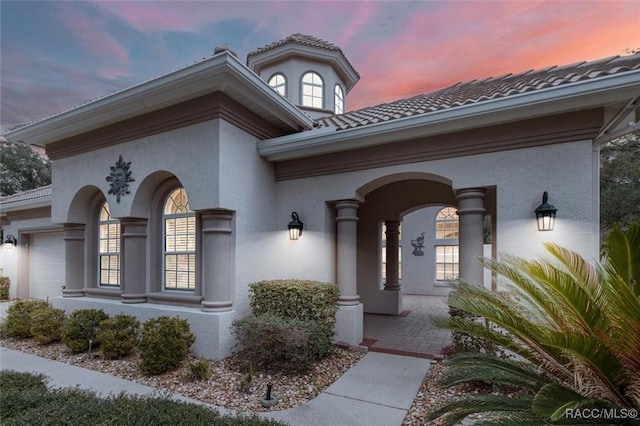 exterior entry at dusk with a garage