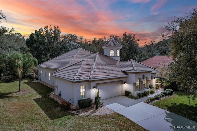 view of front of home with a garage and a lawn