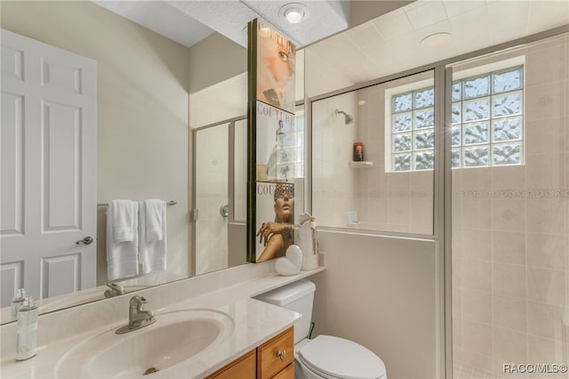 bathroom featuring vanity, toilet, and a stall shower