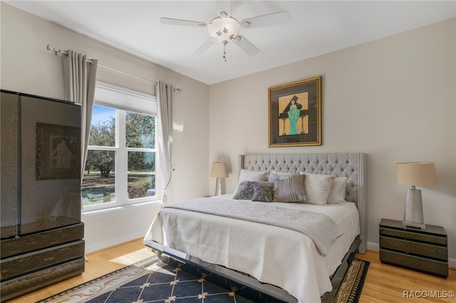 bedroom featuring a ceiling fan, light wood-type flooring, and baseboards